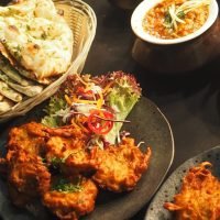 A delicious Indian food spread featuring curries, naan, and colorful salads, perfect for dinner.